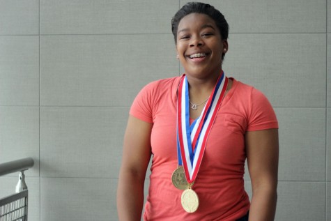 Senior Brittany Marshall pose for a photo with her state medals. 