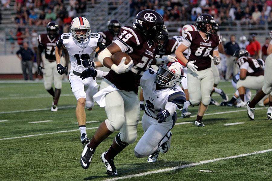 A player from the opposing team attempts to bring down senior Dontae McGee (29).