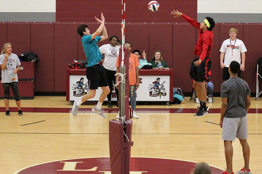 Senior Kyle Schmitz and junior Daniel Rosado go head to head while Daniel spikes the ball over the net.