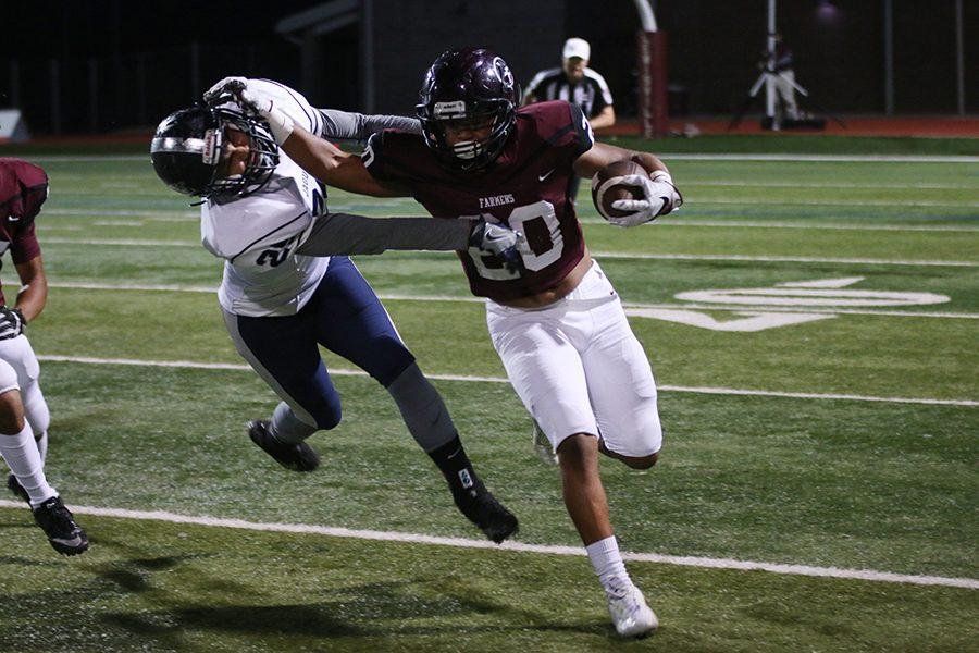 Junior running back De'Mondrick Hunter (20) blocks Flower Mound's defensive player while running the ball.