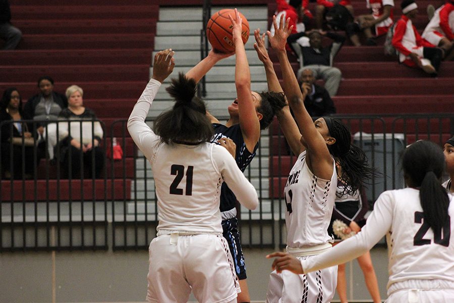 Junior Kennadi Lankford (21) and senior Amani Alston (40) attempt to block the opponent's shot.