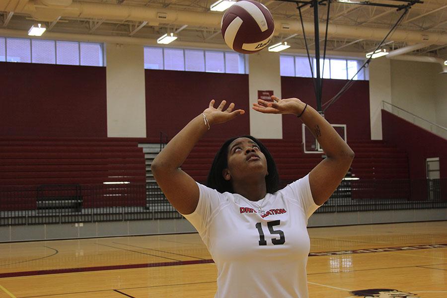 Senior Ryleigh Taylor sets a volleyball in the arena.