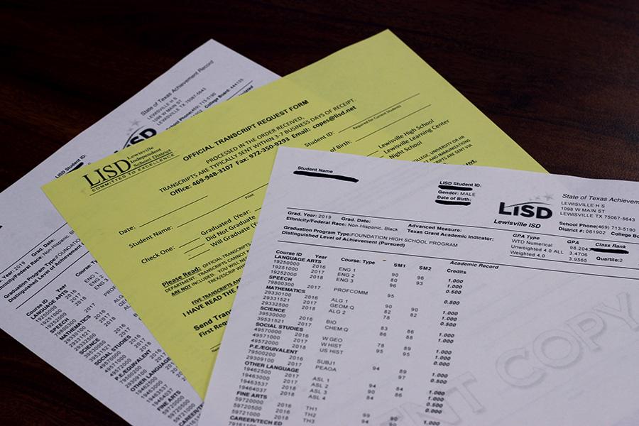 Printed copies of academic records sit on a desk.