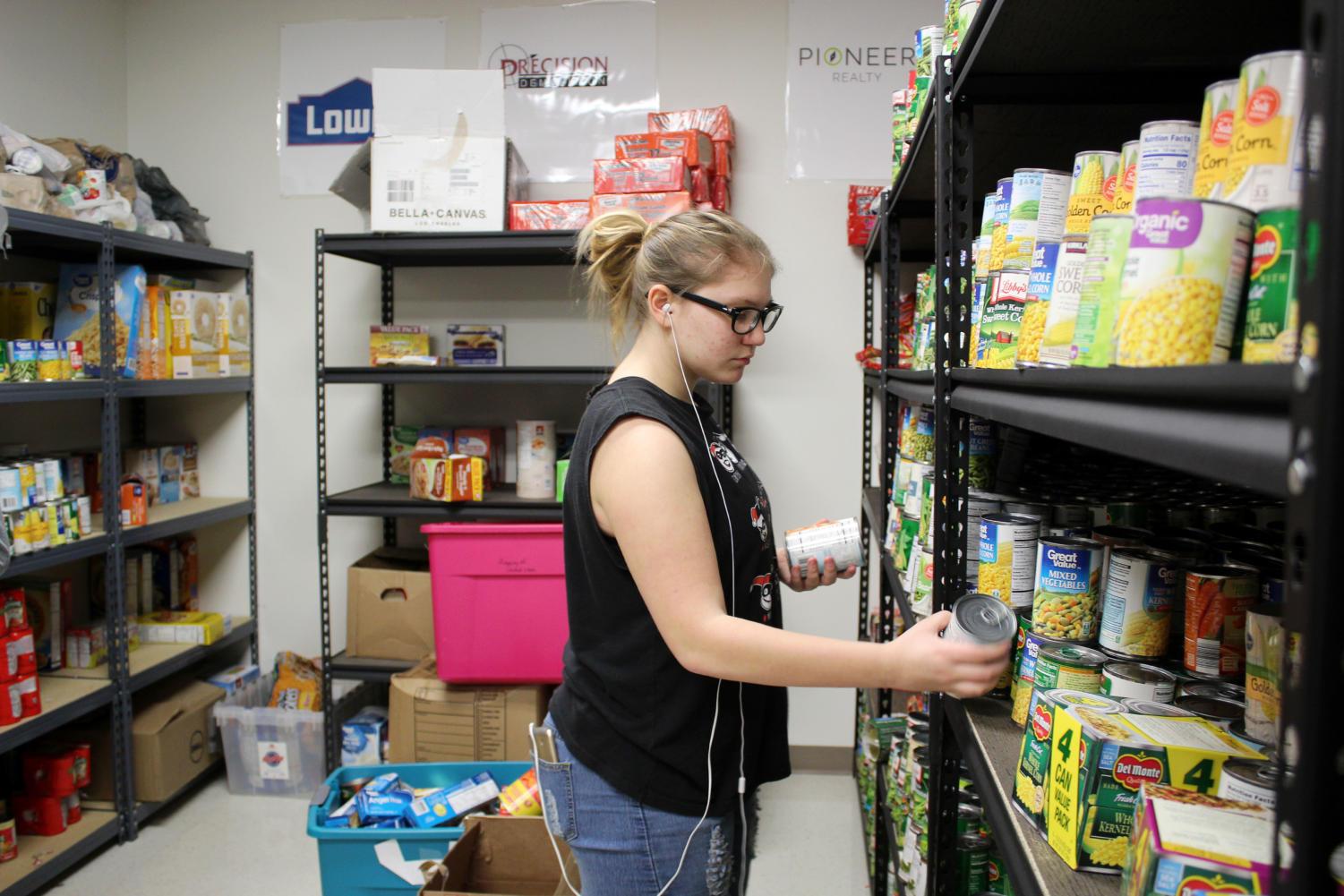 Freshman Josey Lewis sorts cans for the GrubHub food pantry.