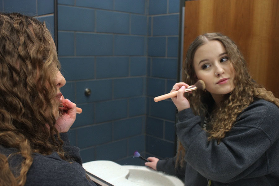 Senior+Madyson+Fletcher+applies+her+highlighter+with+a+makeup+brush.