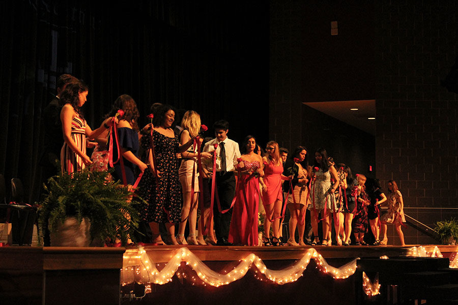 A group of seniors prepare to cut off the ribbon.