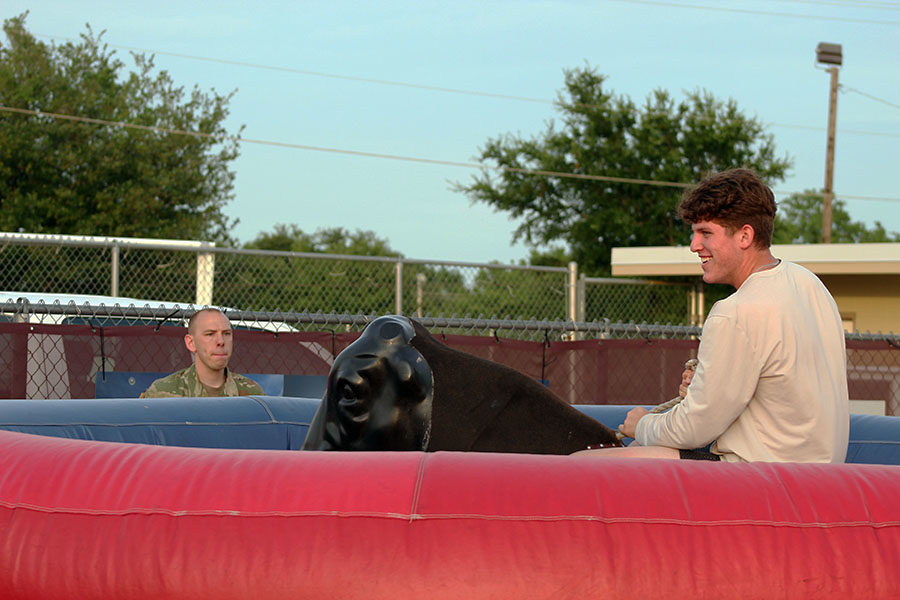 Senior Joey Rochette laughs as he rides the mechanical bull.