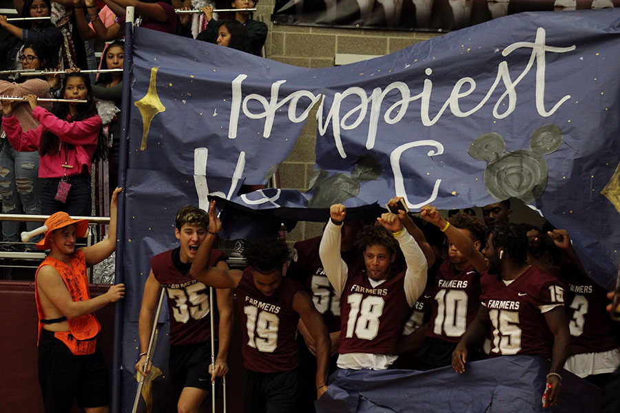 The+Fighting+Farmer+football+team+breaks+through+a+banner+made+by+StuCo+to+kick+off+the+homecoming+pep+rally+on+Friday%2C+Oct.+4.